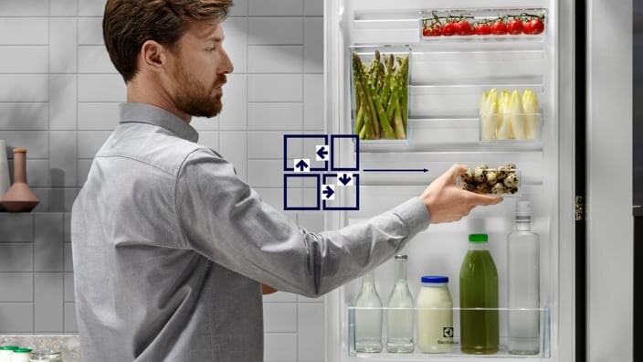 Uomo che organizza la porta del frigorifero