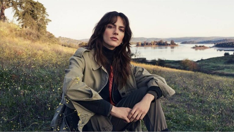 Donna seduta sull’erba nella natura.