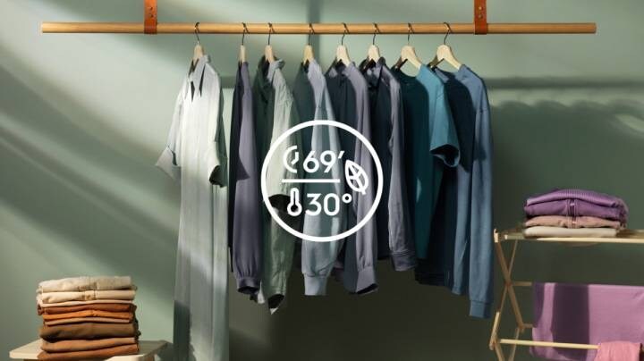 Simbolo di lavaggio a 30 gradi e vestiti sullo sfondo